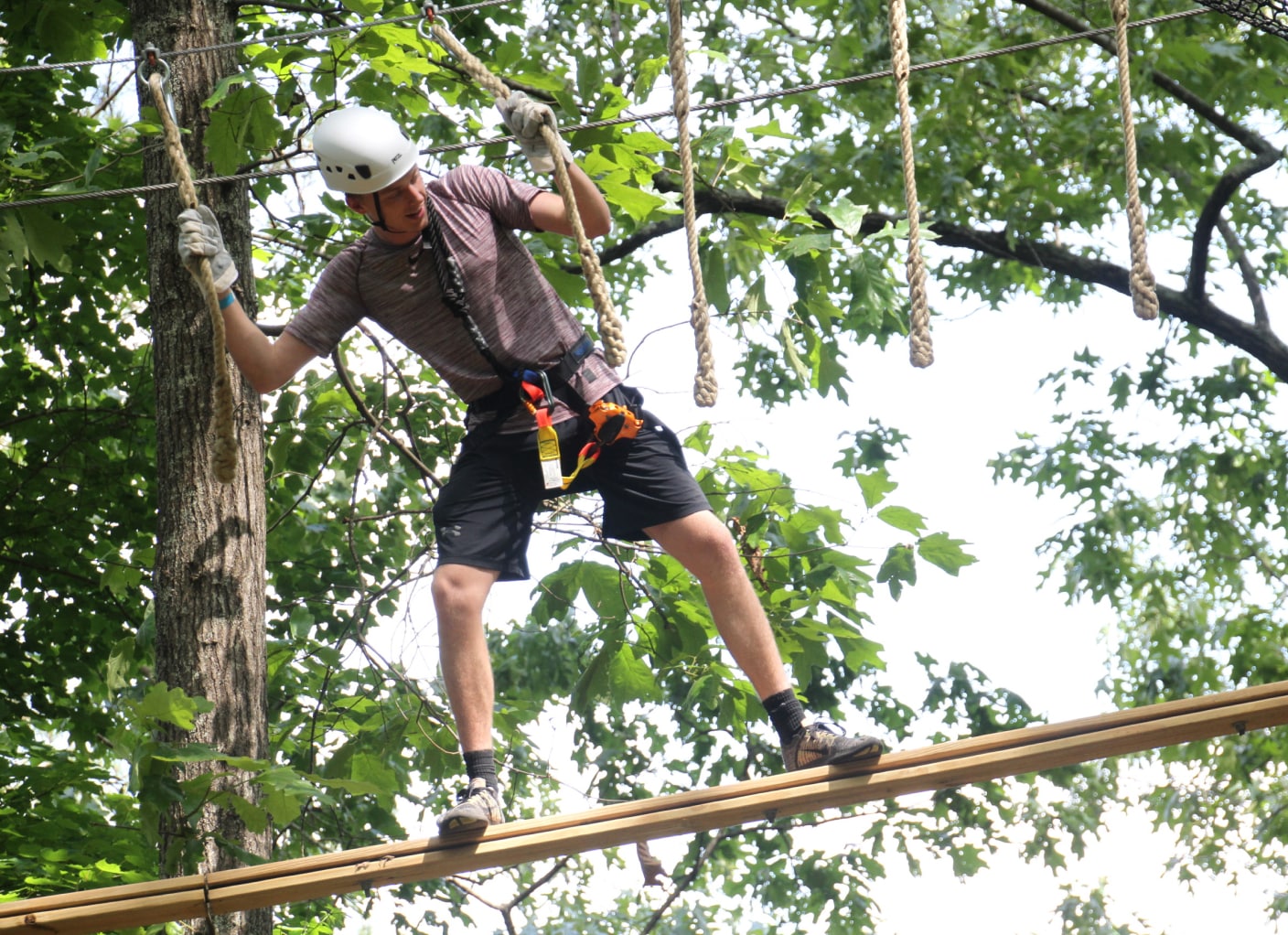 man on aeraal challenge course with ropes course