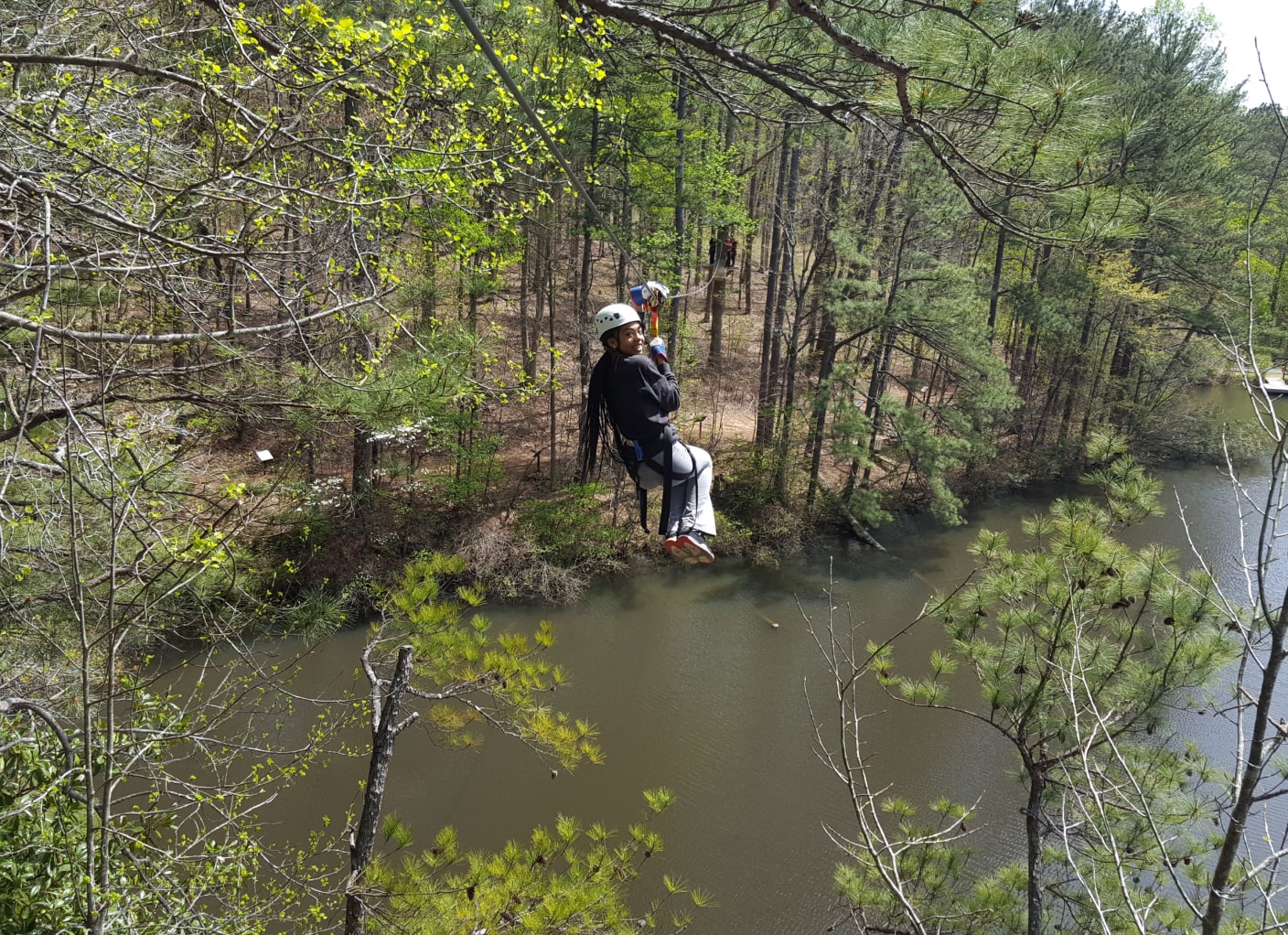person on canopy tour ziplining across water at georgia zipline adventure park