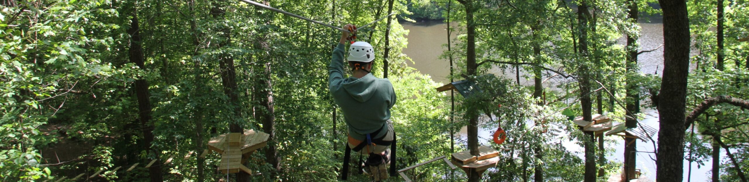 man ziplining through canopy and aerial adventure course